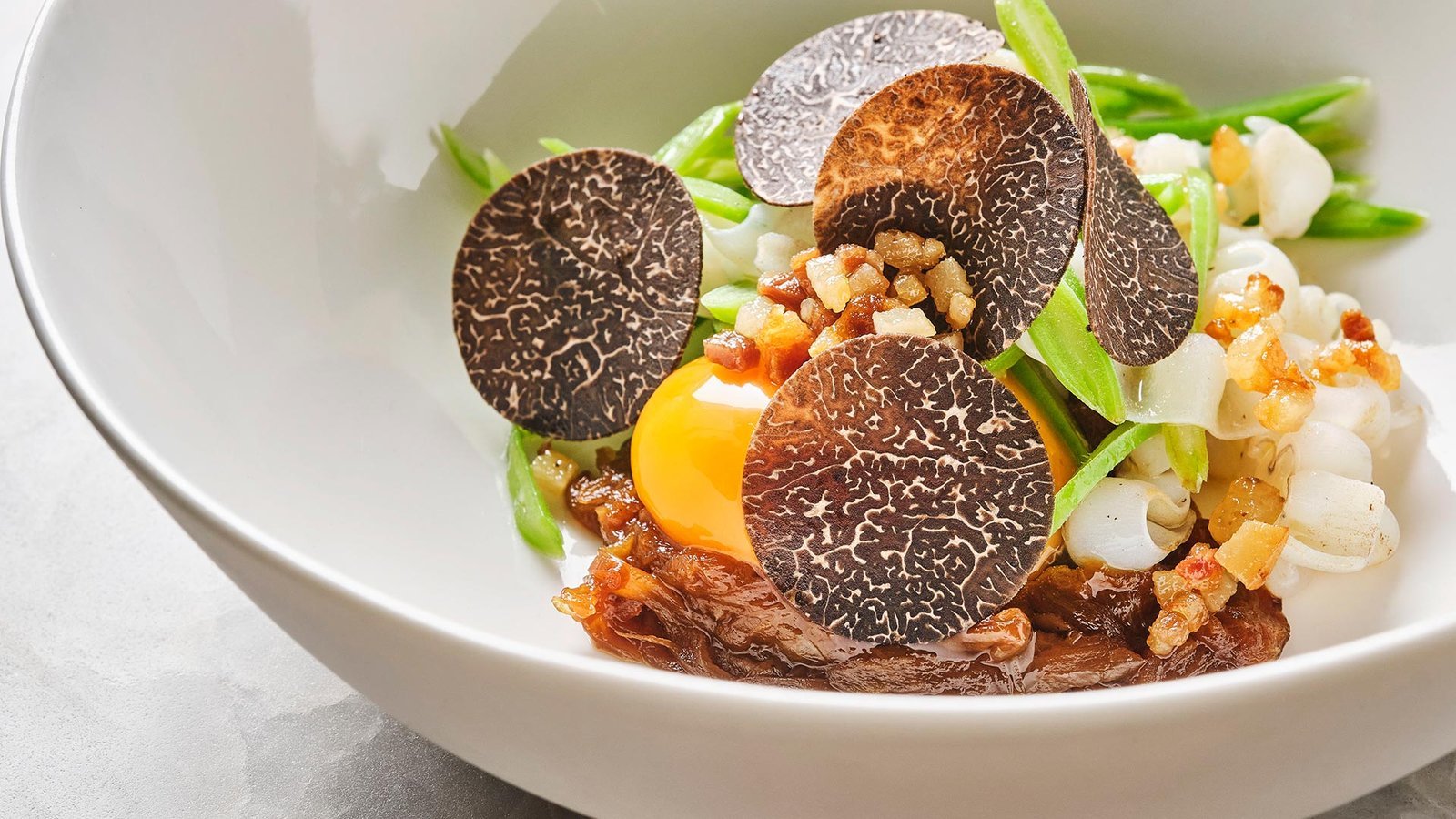 Plato con trufa negra, yema de huevo y carrillera en su jugo.